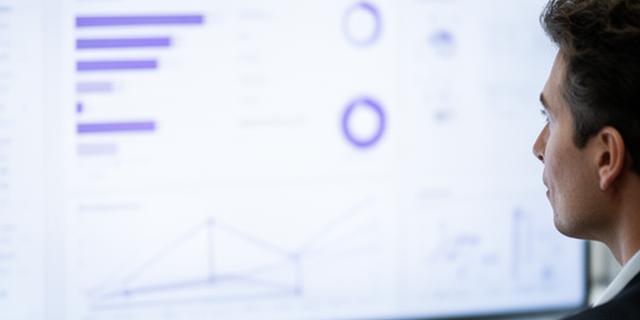 Аналітикиня переглядає дашборд продуктивності сервісу на світлому екрані з графіками та помітками конфіденційності